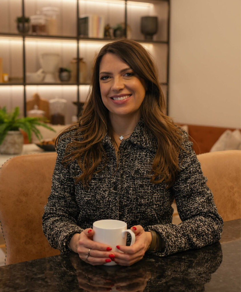 Charlotte Wood from Charlotte Louise Therapy sat in a therapy room with a cup of tea